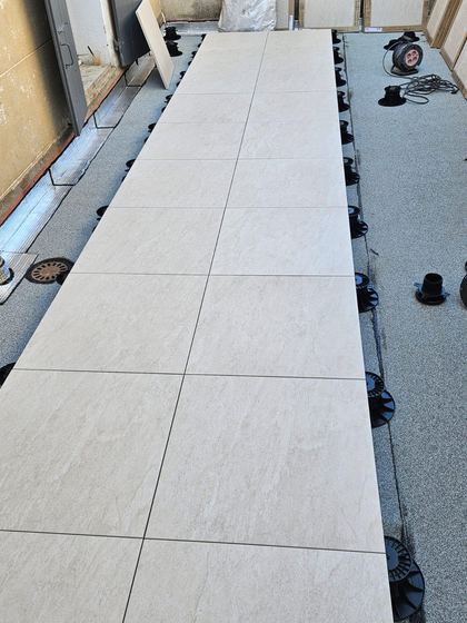 Dalles en cours de pose (terrasse : carrelage remplacé par des dalles sur plots)