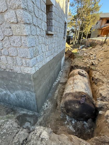 Tranchée ouverte au pied du mur (soubassement de maison en pierre)