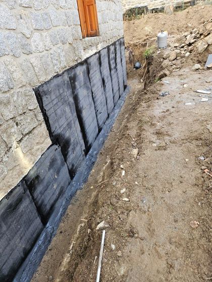 Pose de la membrane bitumineuse (soubassement de maison en pierre)