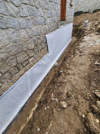 Soubassement protégé, prêt à remblayer (soubassement de maison en pierre)