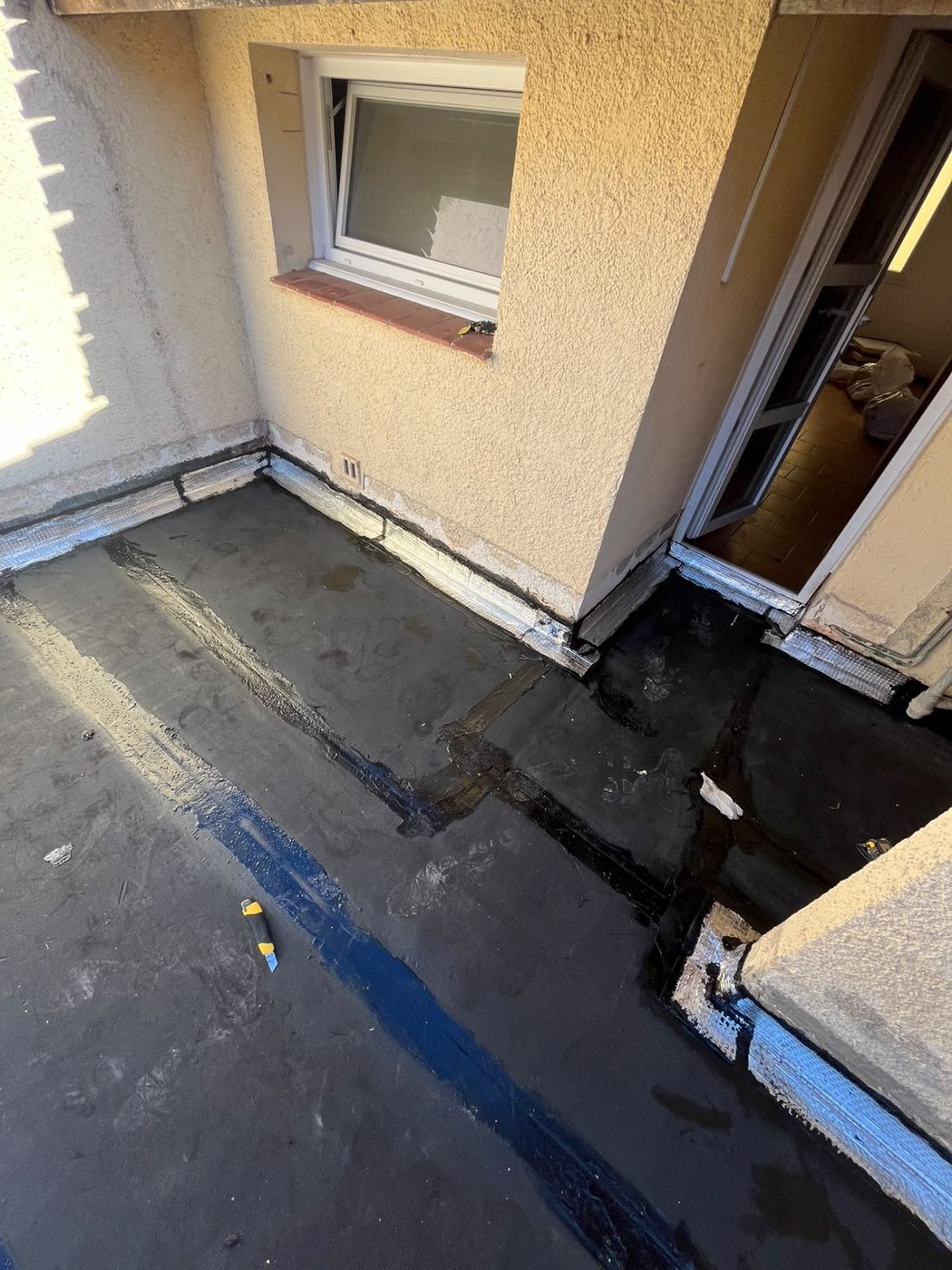 Traitement des relevés d'étanchéité au pied d'une porte-fenêtre sur une terrasse à Thuir