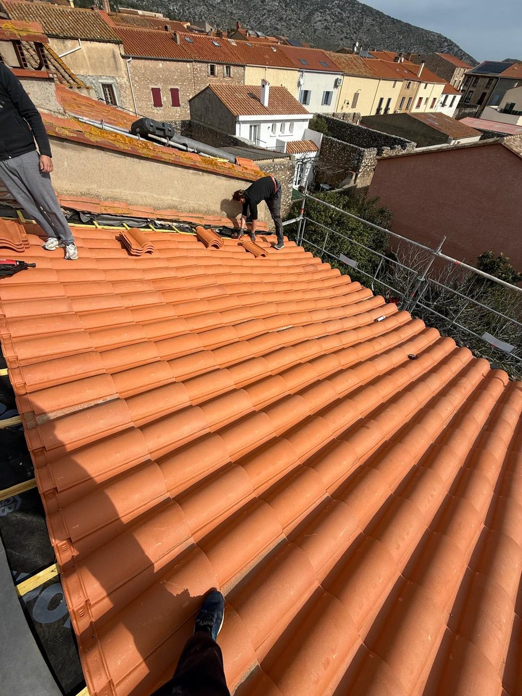La couverture neuve en cours, face aux toits du village (réfection de toiture à Opoul-Périllos)